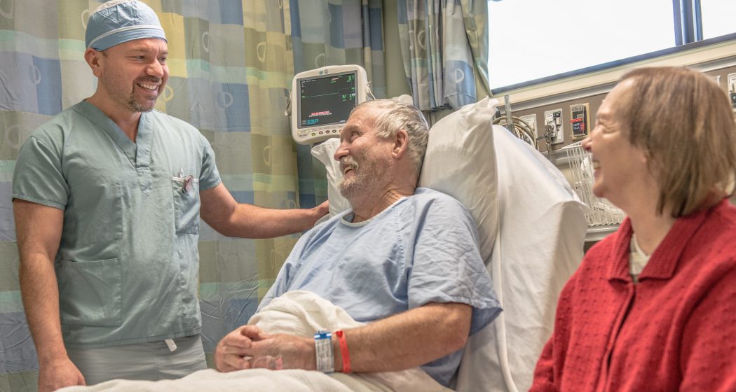 Image of a doctor, with an elderly patient and his wife