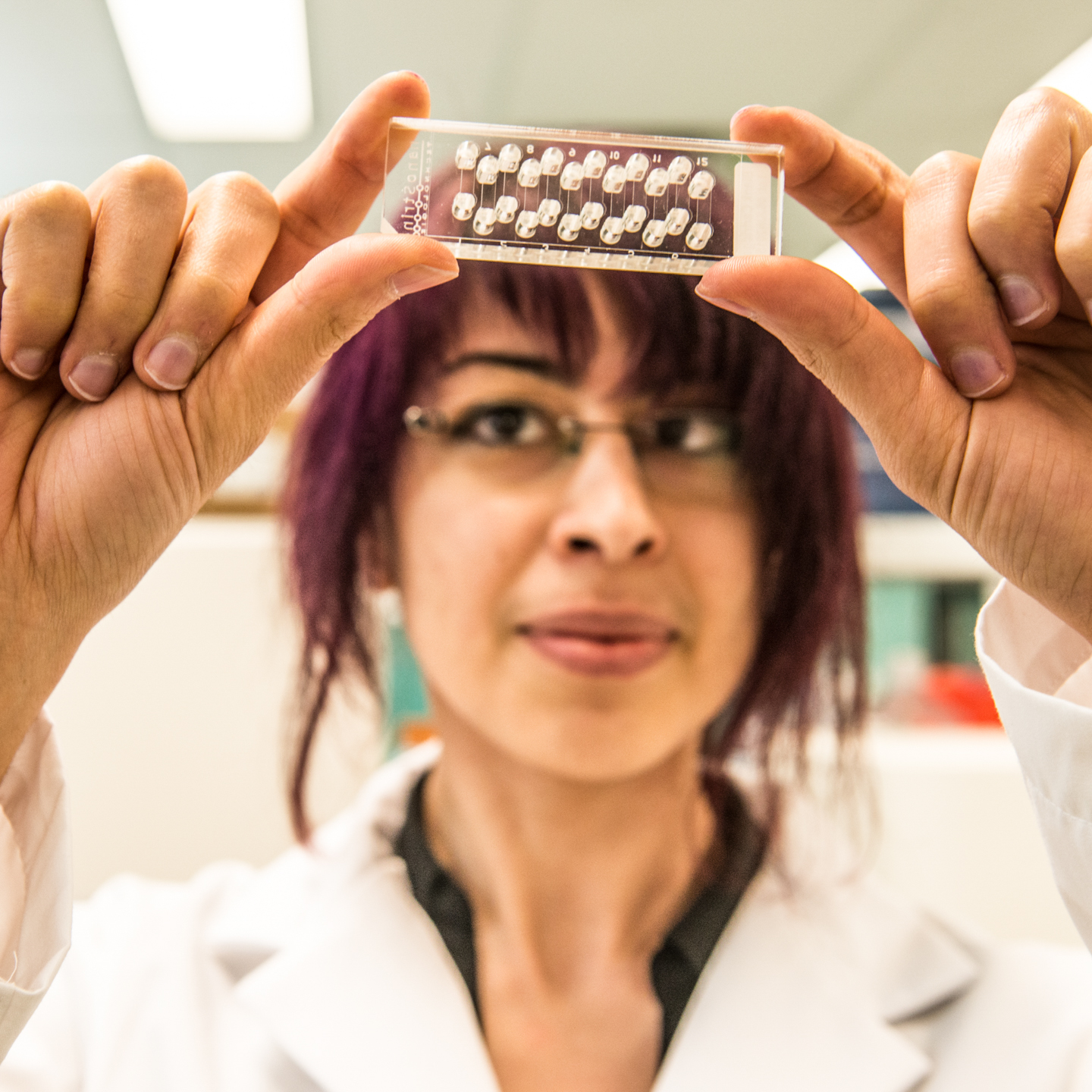 Basak holds up and examines glass.