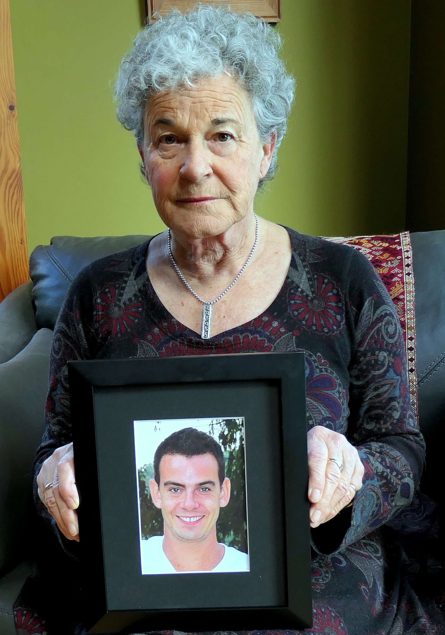 Image of Leslie McBain holding a picture of her son